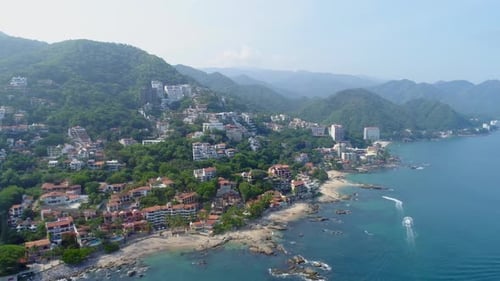 Aerial View of Tropical Coastline and Mountain Community