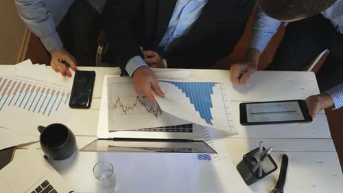 Male and Female Hands of Coworkers Comparing Sales Result Graph on Paper with Chart on Screen of