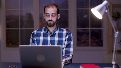 Young Adult Working at Laptop in Home Office
