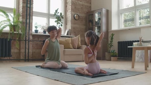 Woman and Girl Doing Yoga in Living Room