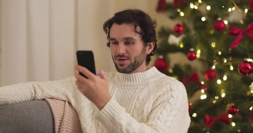 Man Smiles Using Cell Phone at Christmas