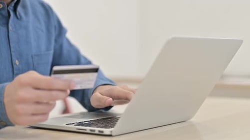 Person using Laptop and Credit Card Indoors