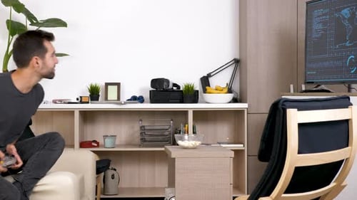 Young Man Plays Video Games at Home