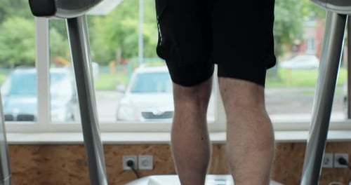 Back View of Athletic Man Walking on Treadmills