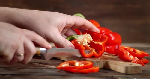Person Cutting Red Bell Pepper with a Knife