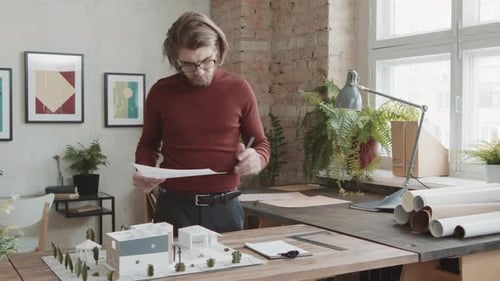 Male Architect Working On House Layout In Modern Office