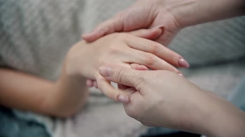 Massage - Masseuse knetet die schönen Finger einer jungen Frau