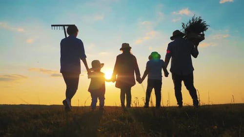Family Walking Together at Sunset on Farmland