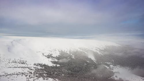 Schneebedeckter Berggipfel in den Wolken