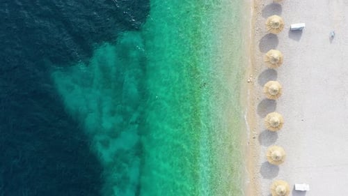 Aerial view on the seashore with umbrella. Vacation and adventure.