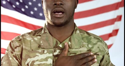 Soldier in Uniform Stands Before American Flag