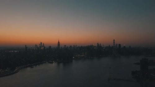 AERIAL: Over East River Showing Manhattan New York City Skyline in Beautiful Dawn Sunset Orange