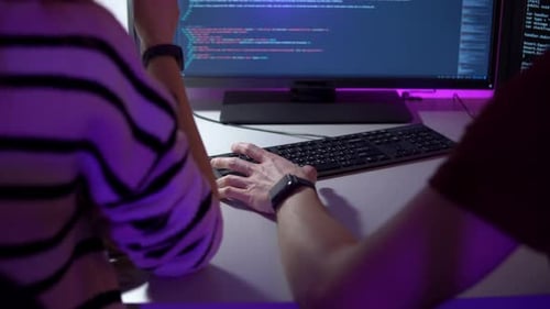 Team Work of Two Programmers Who are Sitting in Front of Computer Screen and Typing Javaskript
