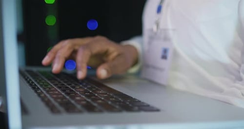 Typing on Laptop in Dark Data Center