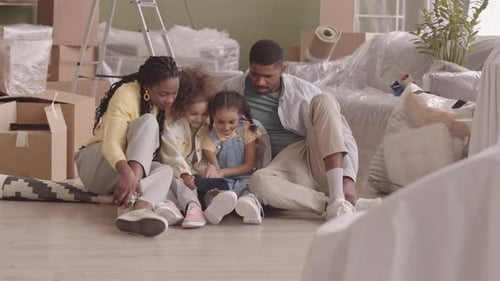 African American Family Watching Funny Videos in New Apartment