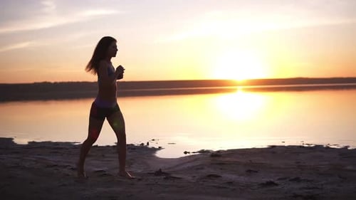 Woman Jogging on Beach at Sunrise