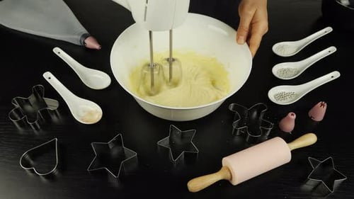 Weibliche Hände mischen Teig in Schüssel mit Mixer