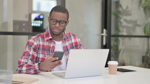 Young Adult on Phone Working at Desk