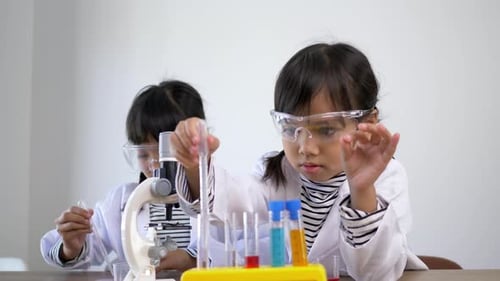 jolies sœurs aiment expérimenter avec des liquides en cours de sciences