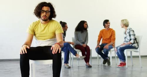 Man Sitting Anxiously at Group Therapy Meeting