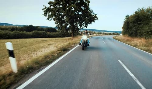 Motorcyclist Rides on a Winding Country Road