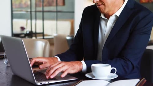 Professional Man Works on Laptop in Modern Workplace