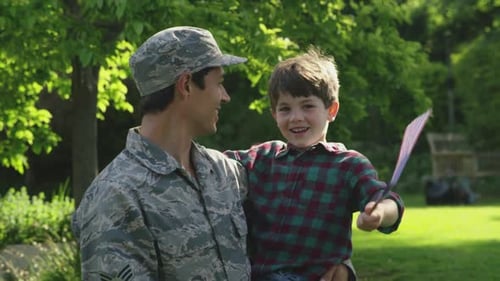 Military Adult Holds Smiling Child Waving American Flag