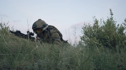 Soldier Aiming Rifle Lying in Grass Outdoors