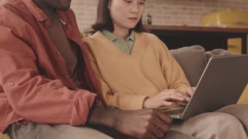 Couple Relaxing at Home Using a Laptop