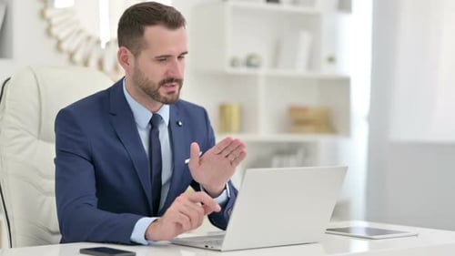 Businessman Doing Video Call on Laptop in Office