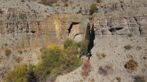 Waterfall Cascading Down Rocky Cliffside in Remote Canyon