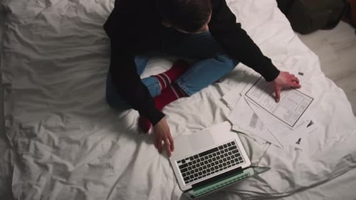 Person Works on Laptop in Bed