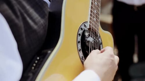 The old man's hand playing acoustic guitar. He plays folk song