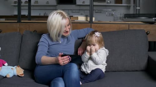 Woman and Child Enjoying Tablet Time on Couch