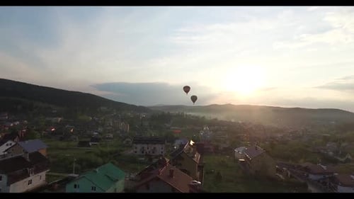 Two Balloons Are Flying To Meet the Sunset. Aerial View