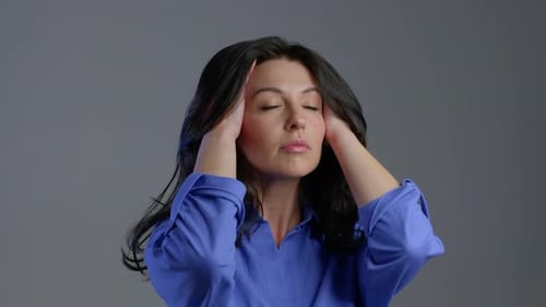 Tired Woman Having Headache, Studio portrait.Lady Putting Hands on Head