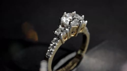 Gros plan extrêmement détaillé de la bague en diamant lors de la rotation sur fond sombre