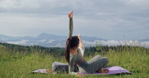 Women Doing Partner Yoga in Grassy Field