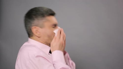 Allergy, Rhinitis, Sickness. Diseased Male Sneezing and Wiping Nose With Tissue