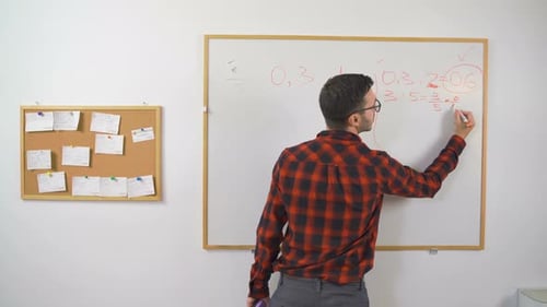Instructor Writing Equations on Whiteboard