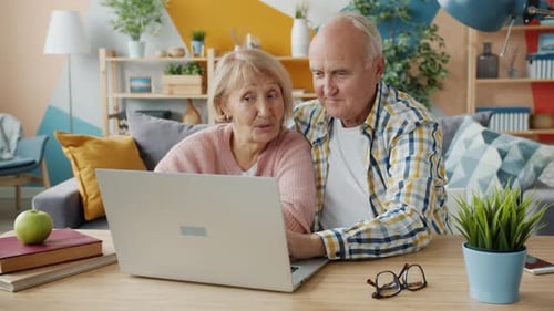 Senior Couple Using Laptop Computer Together at Home