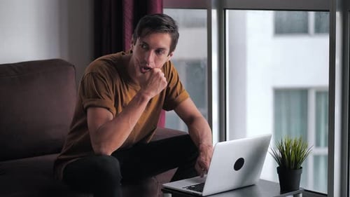 Man Using Laptop Looking Shocked and Stressed