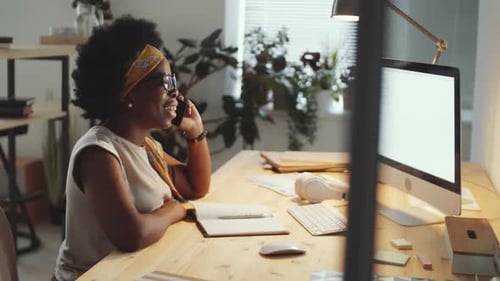 Black Businesswoman Speaking on Phone and Using Computer in Office