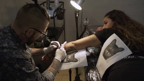 Tattoo Artist Giving Woman a Tattoo in Studio