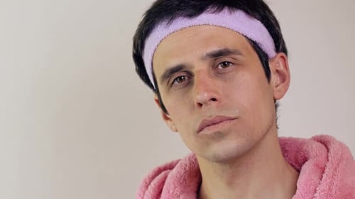 Man Wearing Headband and Pink Robe