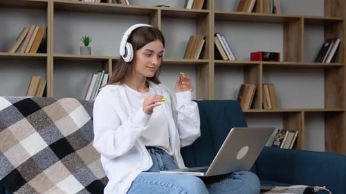 Woman with Laptop Wearing Headphones on a Couch