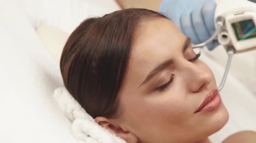 Laser Theraphy on Female Forehead at Cosmetology Center