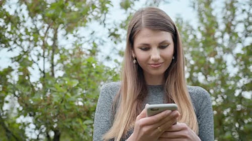 Woman Using Cellphone in the Park