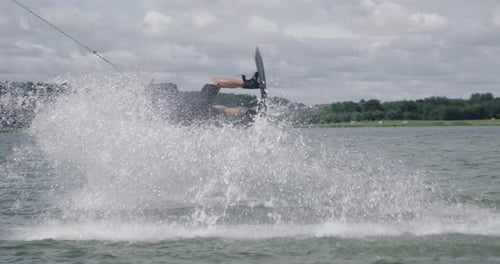Wakeboarding in a Lake Near the Forest, Sportsman Surfs on the Water, Ride on a Wakeboarding Board