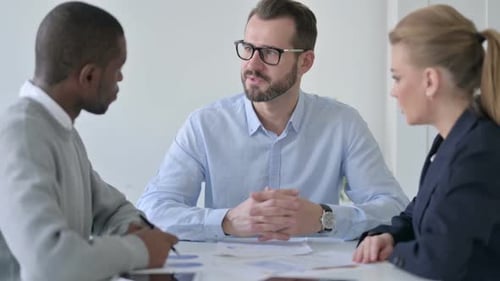 Serious Businessman Talking to Business People in Office